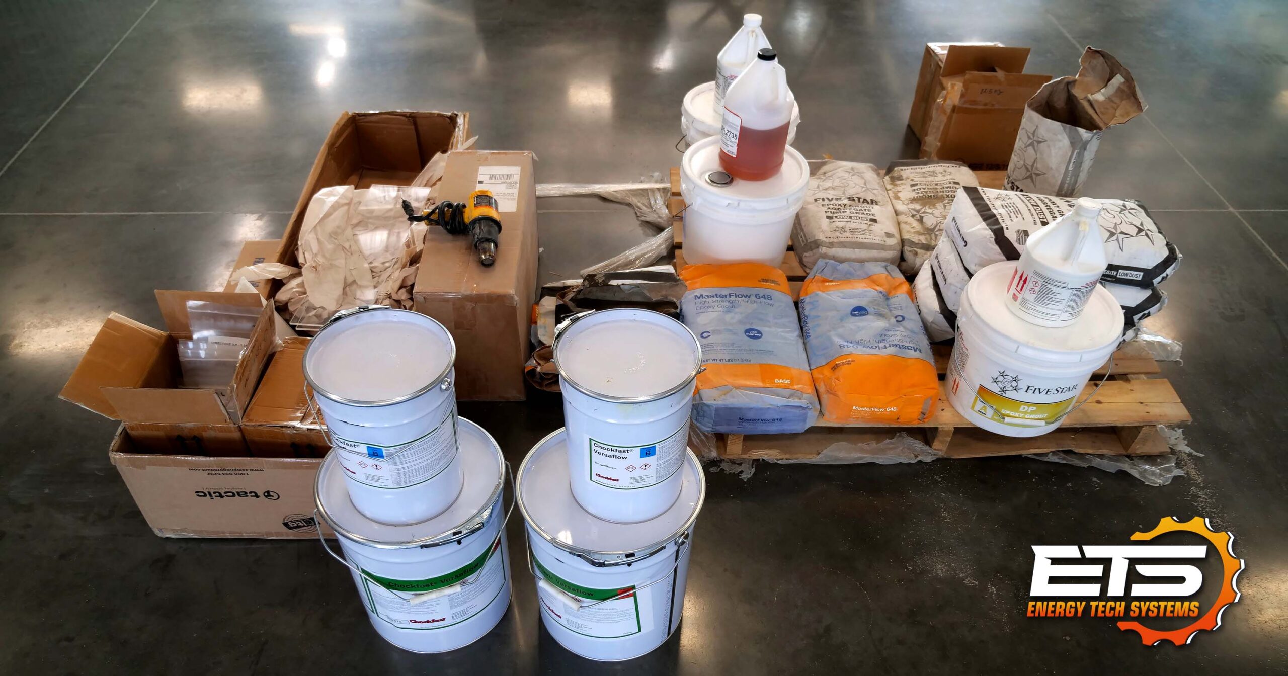 Several epoxy grout products in packaging ready for flow box testing.